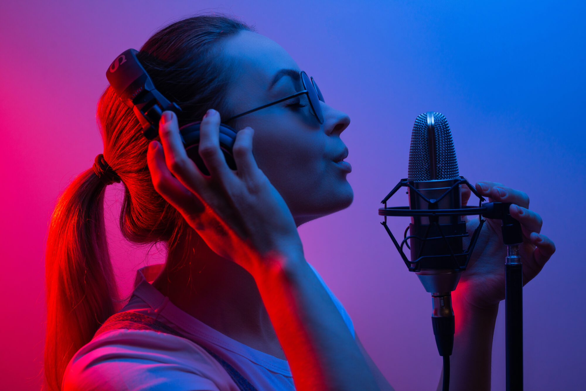 music, show business, people and the voice of a singer or dj with headphones with glasses and a microphone singing a song in the recording studio discoteka, party, light music, party, party, party